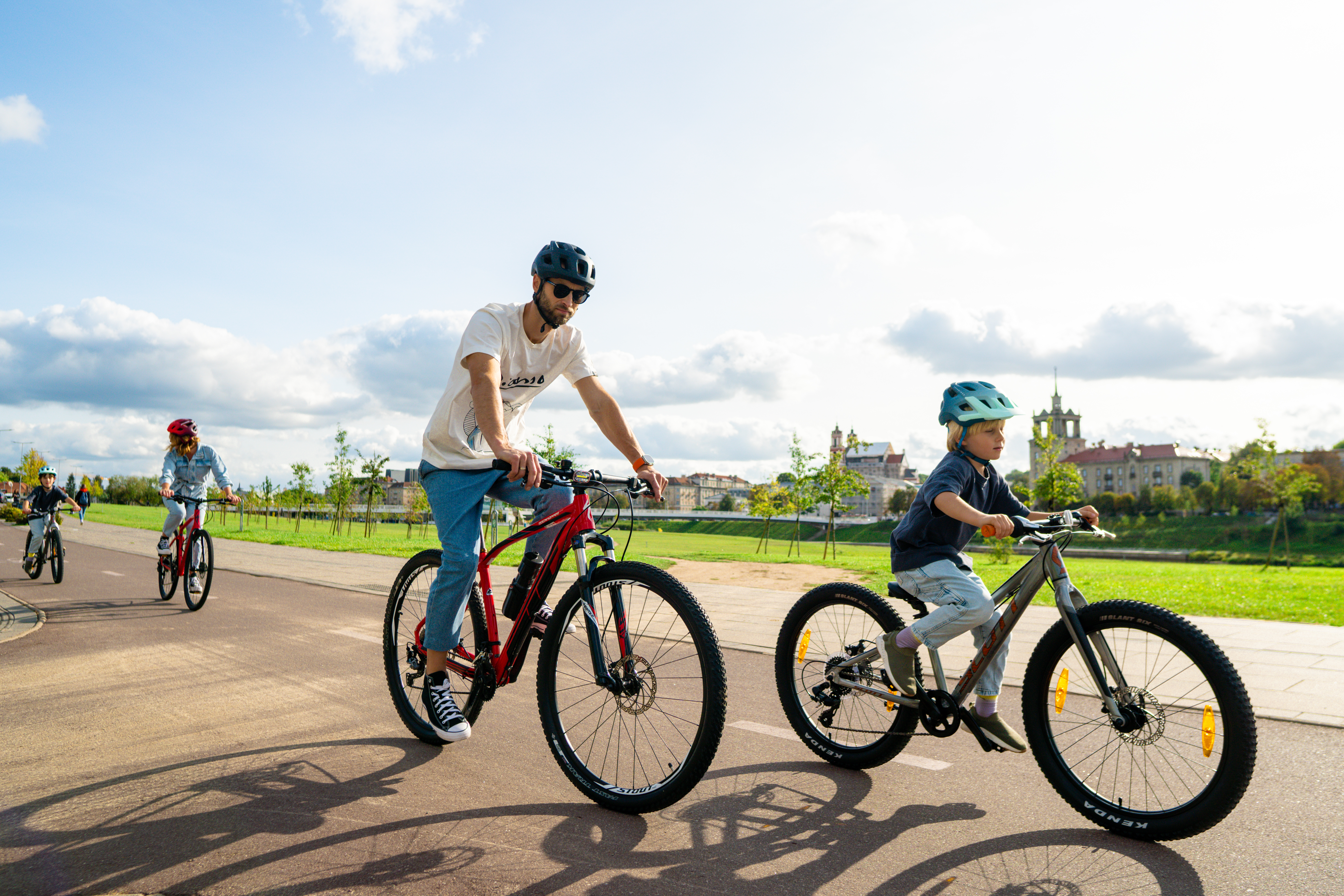 Šeima važinėjasi dviračiais Vilniuje prie upės